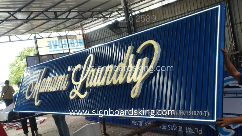 3D Box Up Frontlit Signboard Mamami Laundry dengan huruf akrilik emas bercahaya LED, Ceiling Strip biru dan LED border putih.
