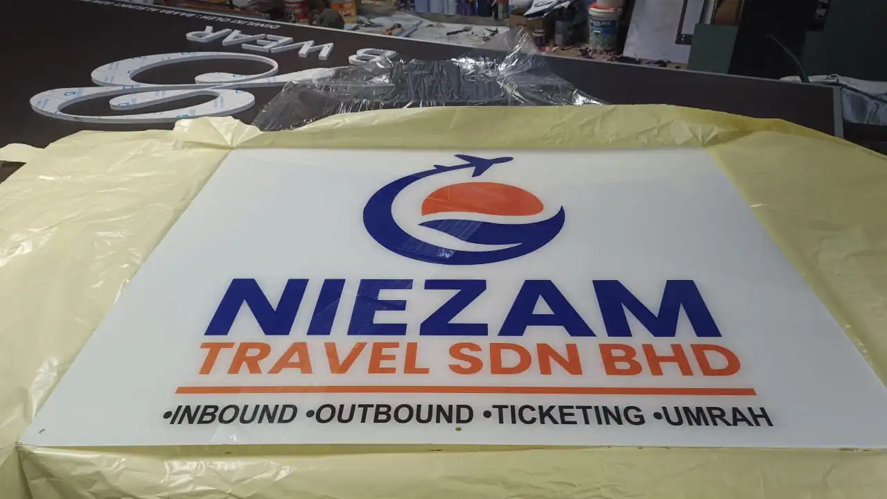 Acrylic Signage Niezam Travel Sdn Bhd dengan logo korporat dan tulisan timbul berkualiti tinggi untuk agensi pelancongan