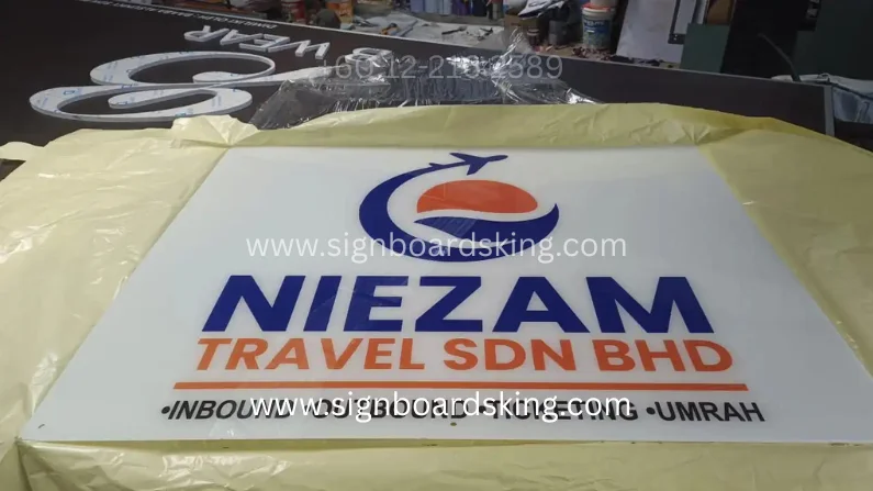 Acrylic Signage Niezam Travel Sdn Bhd dengan logo korporat dan tulisan timbul berkualiti tinggi untuk agensi pelancongan