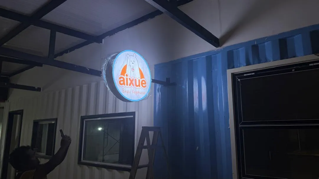 Round lightbox AIXUE dengan pencahayaan LED terang dan reka bentuk bulat moden, meningkatkan visibility premis siang dan malam